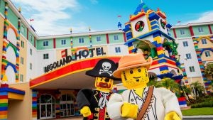 Two characters stand in front of the legoland hotel Florida
